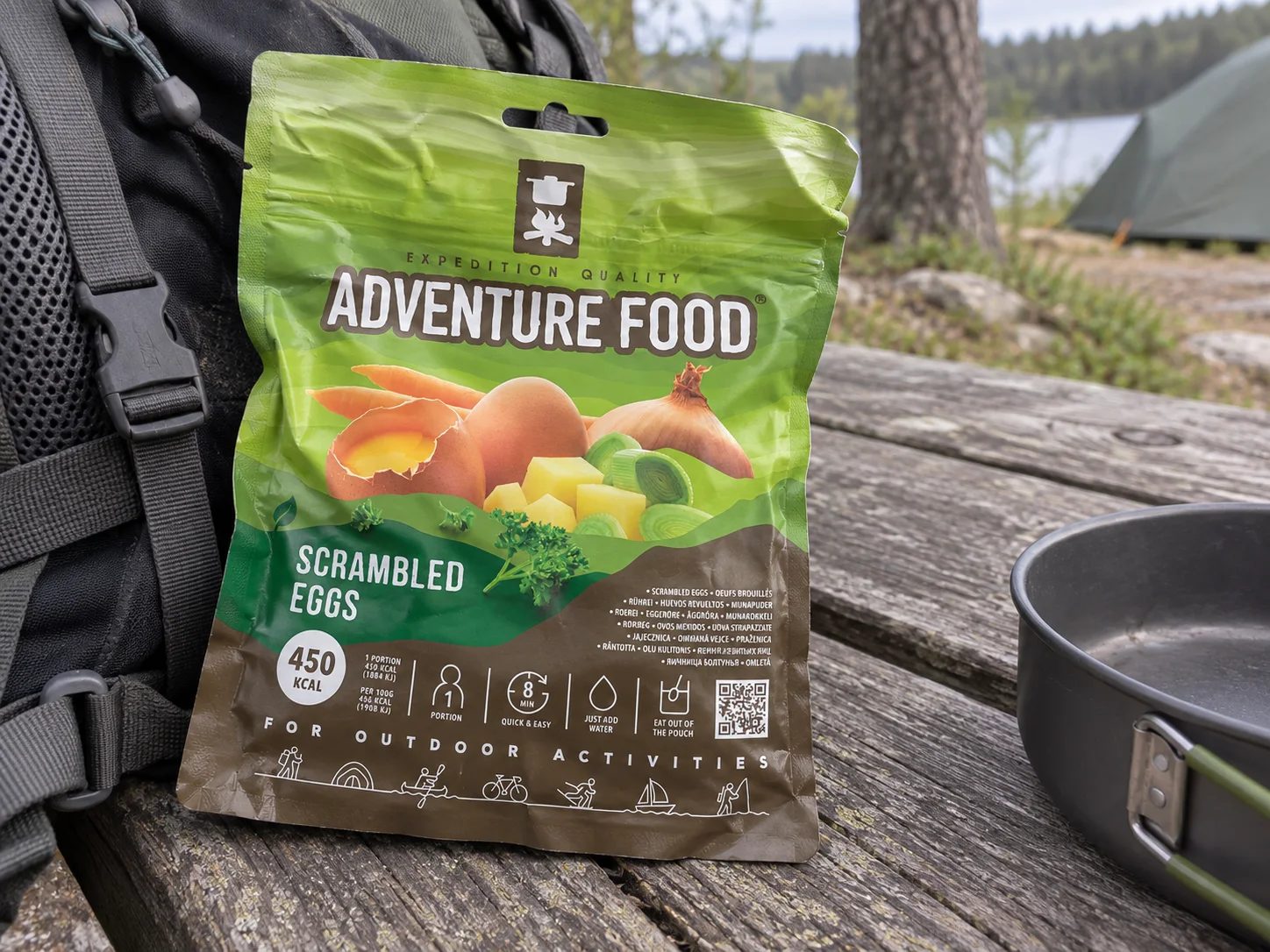 Adventure Food Scrambled Eggs in de verpakking tijdens een pauze onderweg, naast wandeluitrusting.