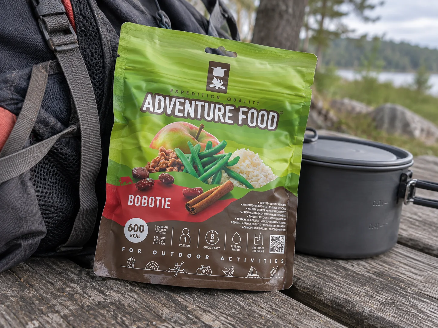 Adventure Food Bobotie in de verpakking tijdens een pauze onderweg, naast wandeluitrusting.
