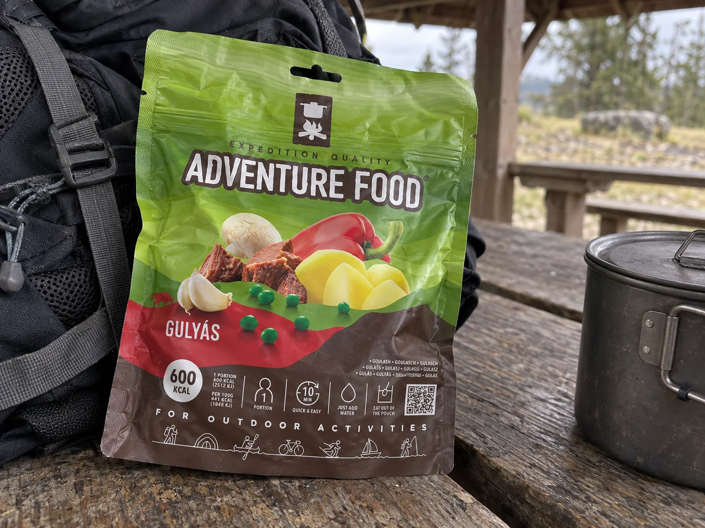 Adventure Food Gulyas in de verpakking tijdens een pauze onderweg, naast wandeluitrusting.