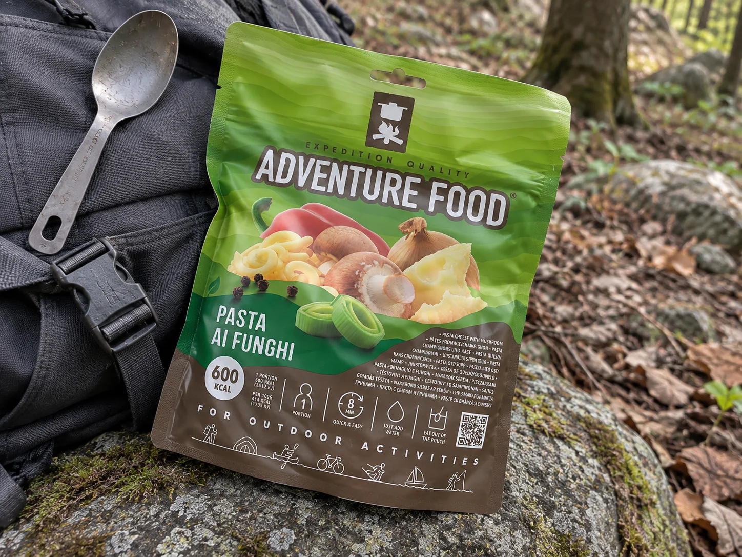 Adventure Food Pasta Ai Funghi in de verpakking tijdens een pauze onderweg, naast wandeluitrusting.