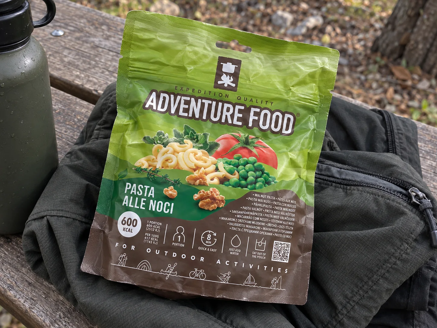 Adventure Food Pasta Alle Noci in de verpakking tijdens een pauze onderweg, naast wandeluitrusting.